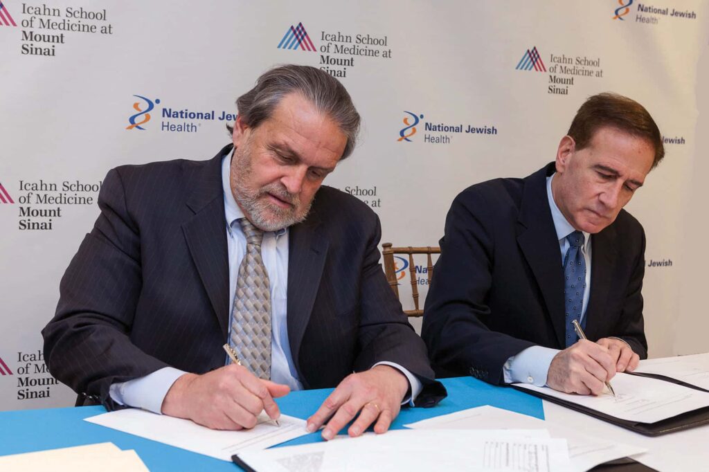 Image: Dennis S. Charney, MD, (left) President of Academic Affairs for the Mt. Sinai Health System and Michael Salem, MD, (right) President and CEO of National Jewish Health, sign an agreement creating The Respiratory Institute in December of 2013. The institute will open its doors October 1, 2014.